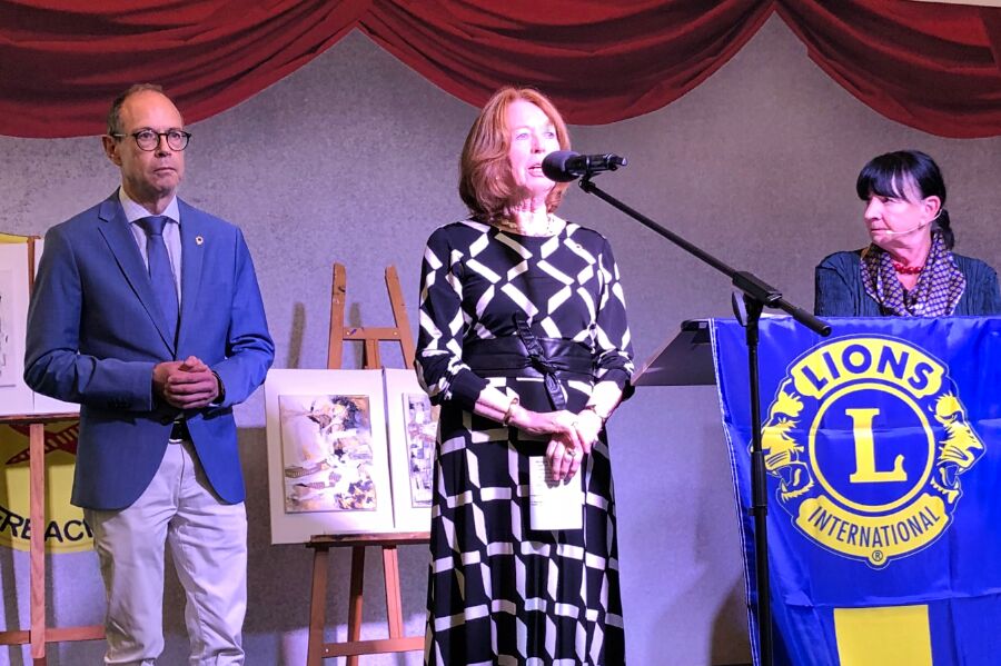 Drei Personen auf der Bühne bei einer Ansprache