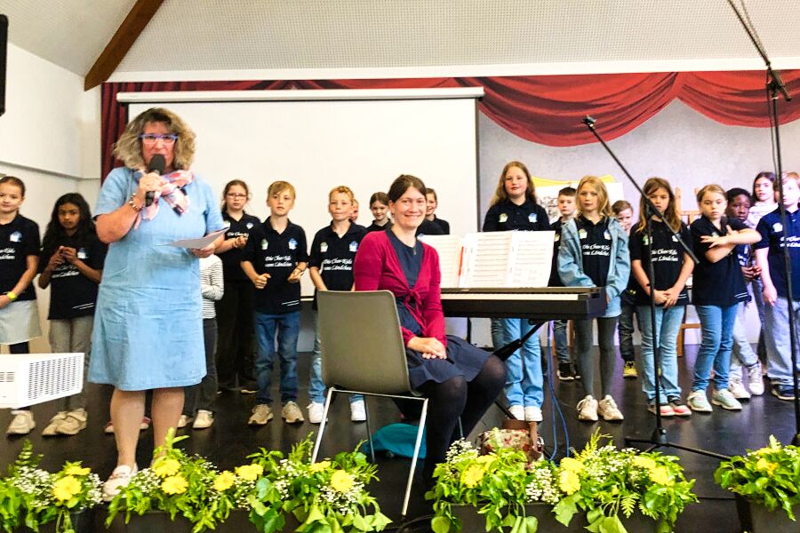 Kinderchor mit Chorleiterin und Schulleiterin