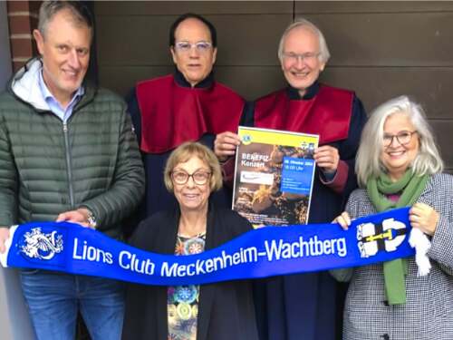 Clubmitglieder und Chorsänger mit Veranstaltungsplakat und Lions-Schal