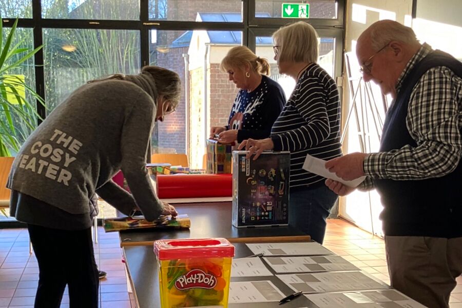 Christian Ullmann mit Helferinnen beim Kindergeschenjke einpacken