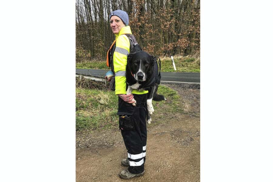 Frau mit auf dem Rücken geschnalltem Hund