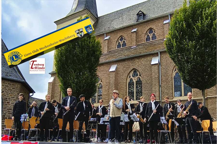 Tomburg Winds mit Dirigenten auf der Bühne vor der Kirche