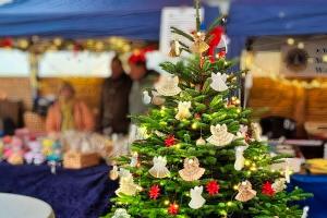 Geschmückter Tannenbaum vor Benefizstand